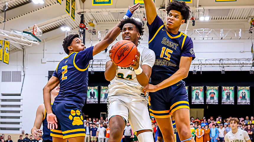 st edward high school basketball player takes a shot between two saint ignatius athletes