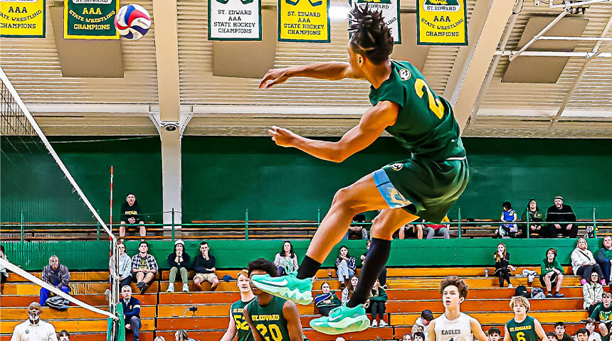 a st edward volleyball athlete goes airborne returning a serve