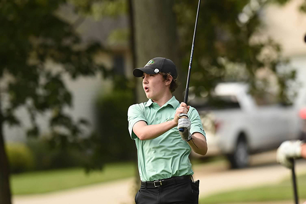 student-athlete in the st. edward high school golf program after taking a swing