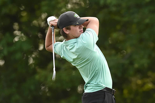 student-athlete in the st. edward high school golf program taking a swing