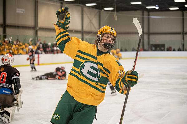 member of the st. edward high school varsity gold hockey team after scoring a goal