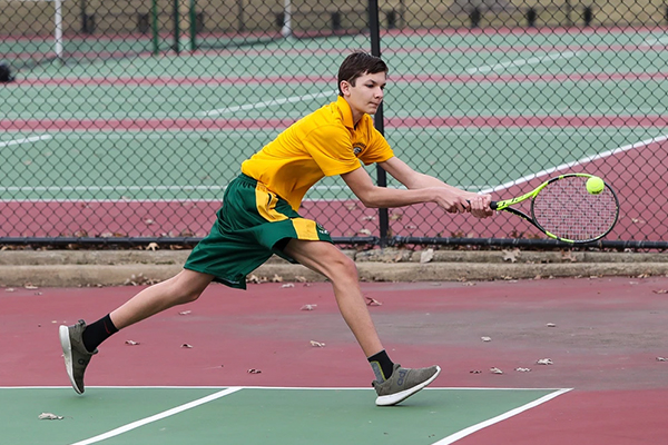 st edward high school tennis player returning the ball