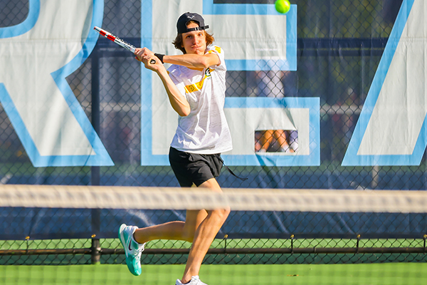 st edward high school tennis player returning a serve