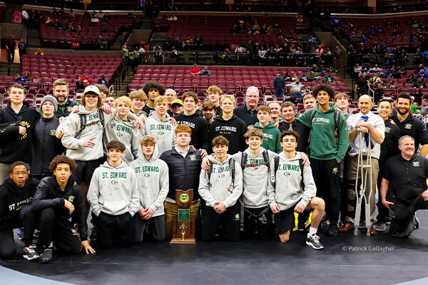 the st. edward high school wresting team posing with the state championship trophy