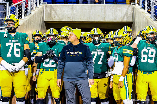 varsity football head coach tom lombardo getting ready to enter the field with the team