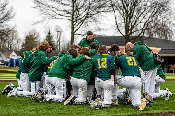 st edward high school varsity baseball team during pre-game prayer