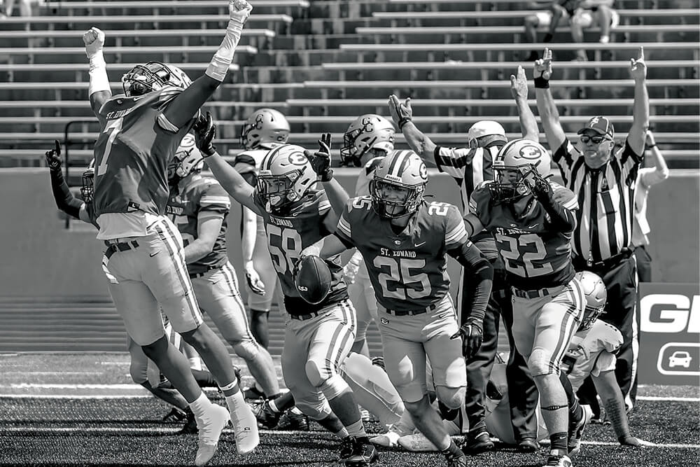 varsity football players celebrate after the team scores a touchdown