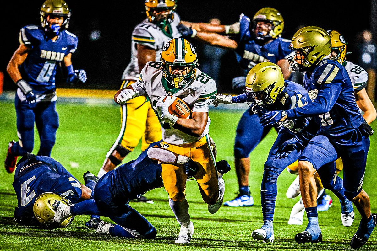 varsity football running back escapes a tackle against archbishop hoban