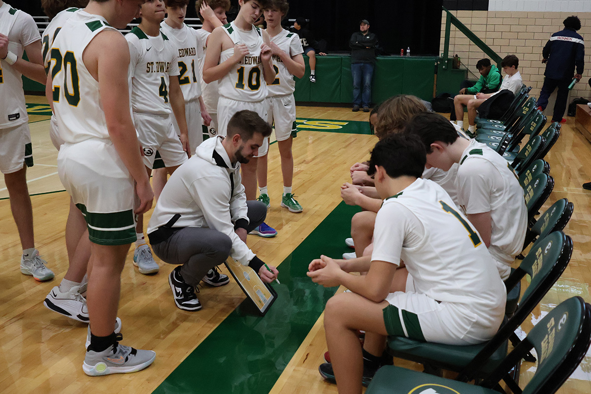 st. edward varsity green basketball team at the bench during a timeout