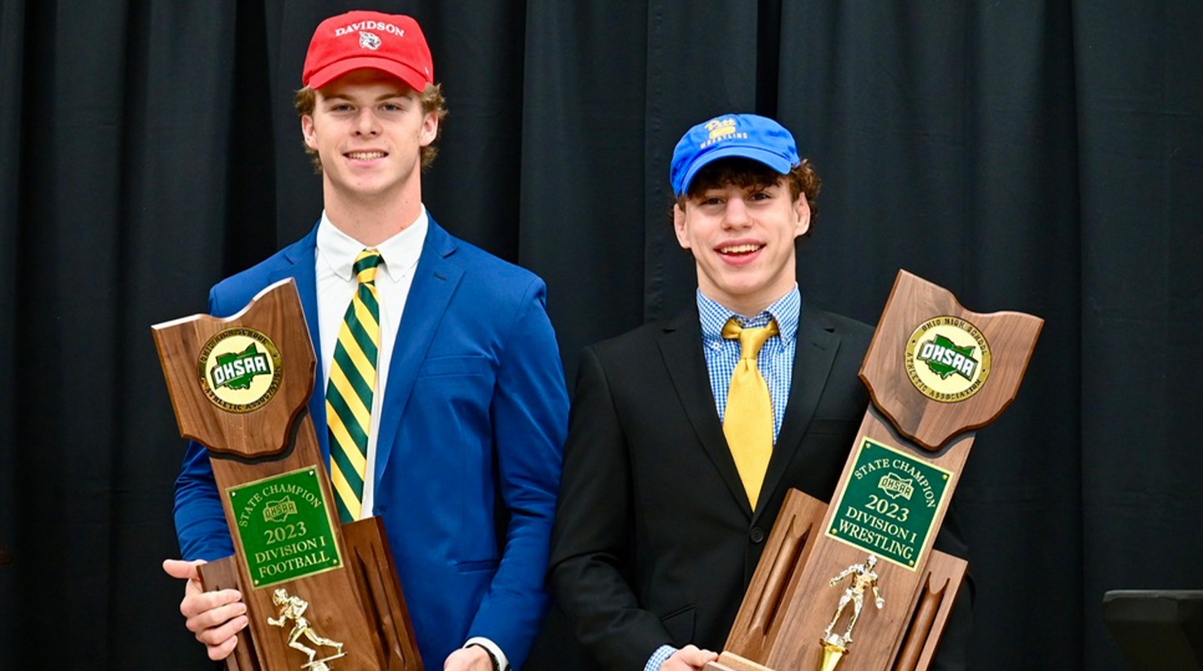 two class of 2024 student athletes hold state championship trophies on signing day