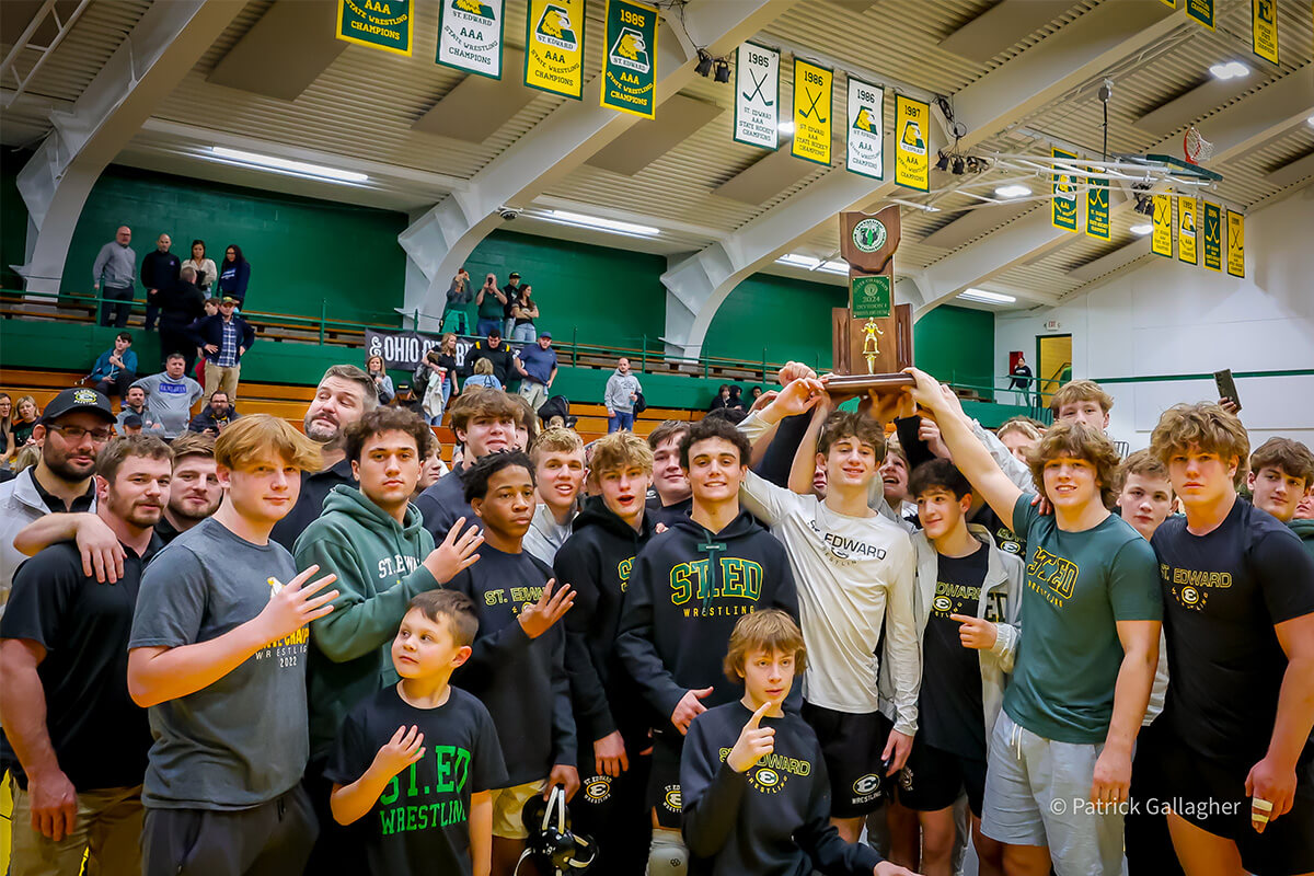 members of the varsity gold wrestling team celebrate after winning the 2024 duals state championship